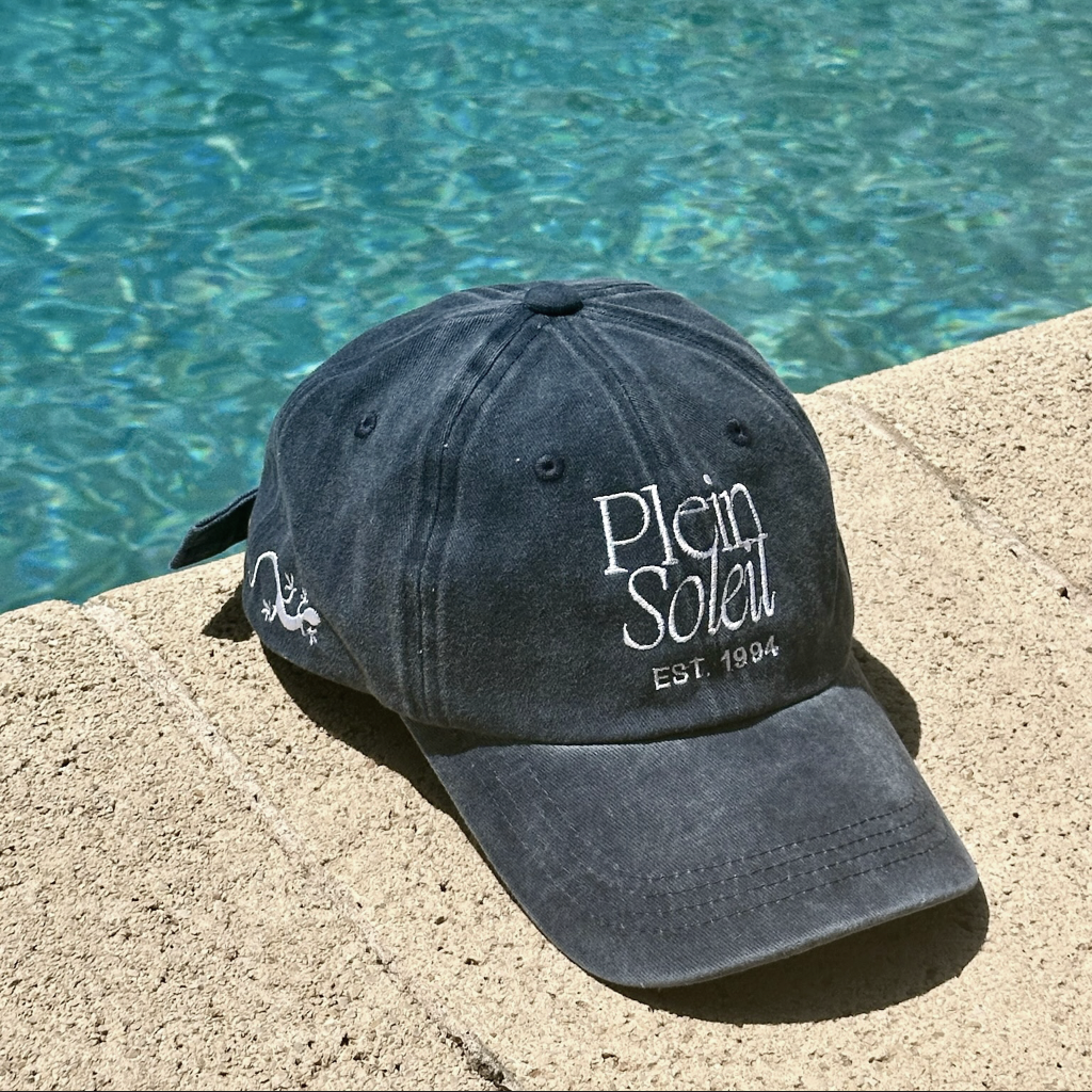 casquette bleue délavée plein soleil sur rebord de piscine