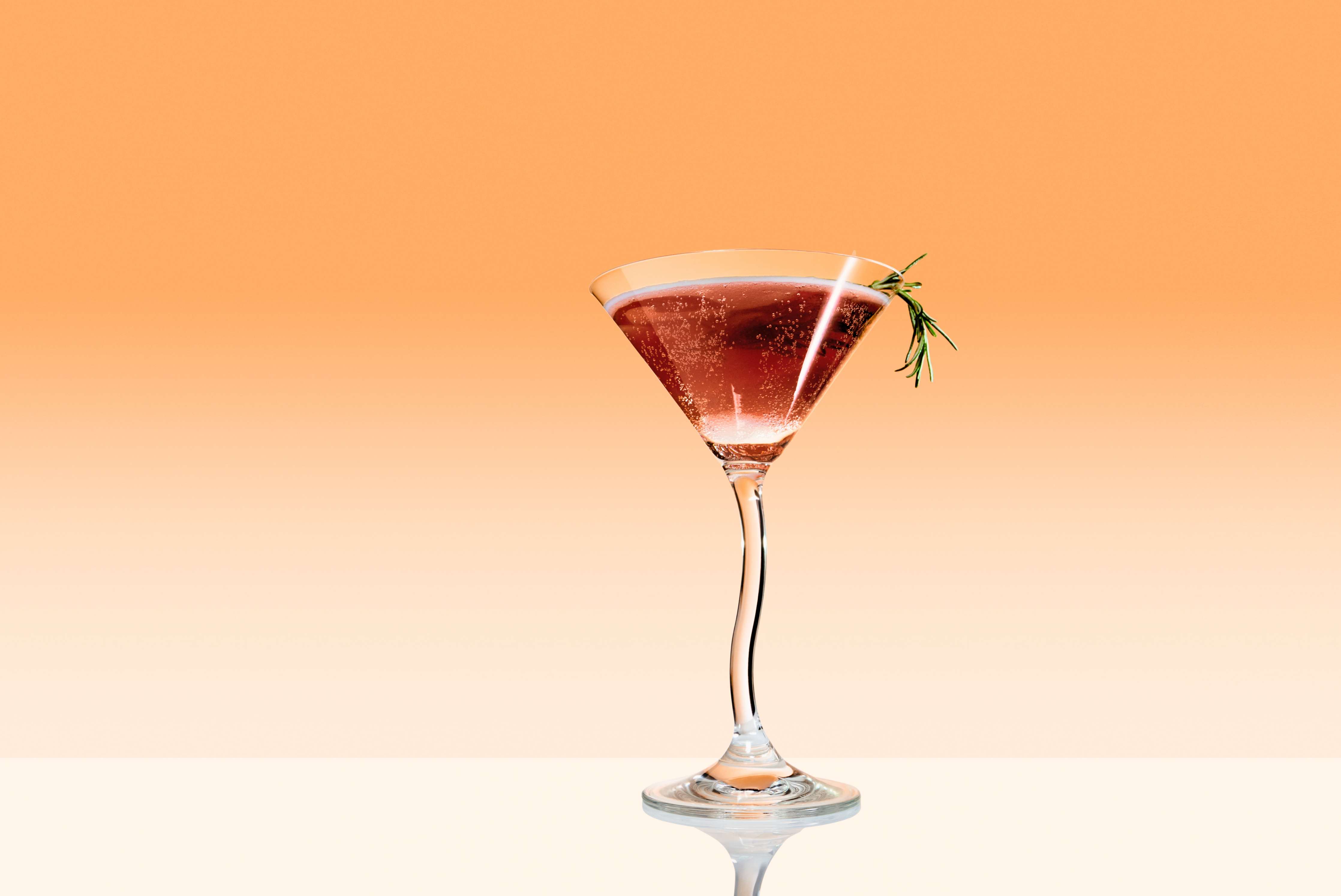 Douze Apricot & Za'atar in a tall martini glass on an orange background
